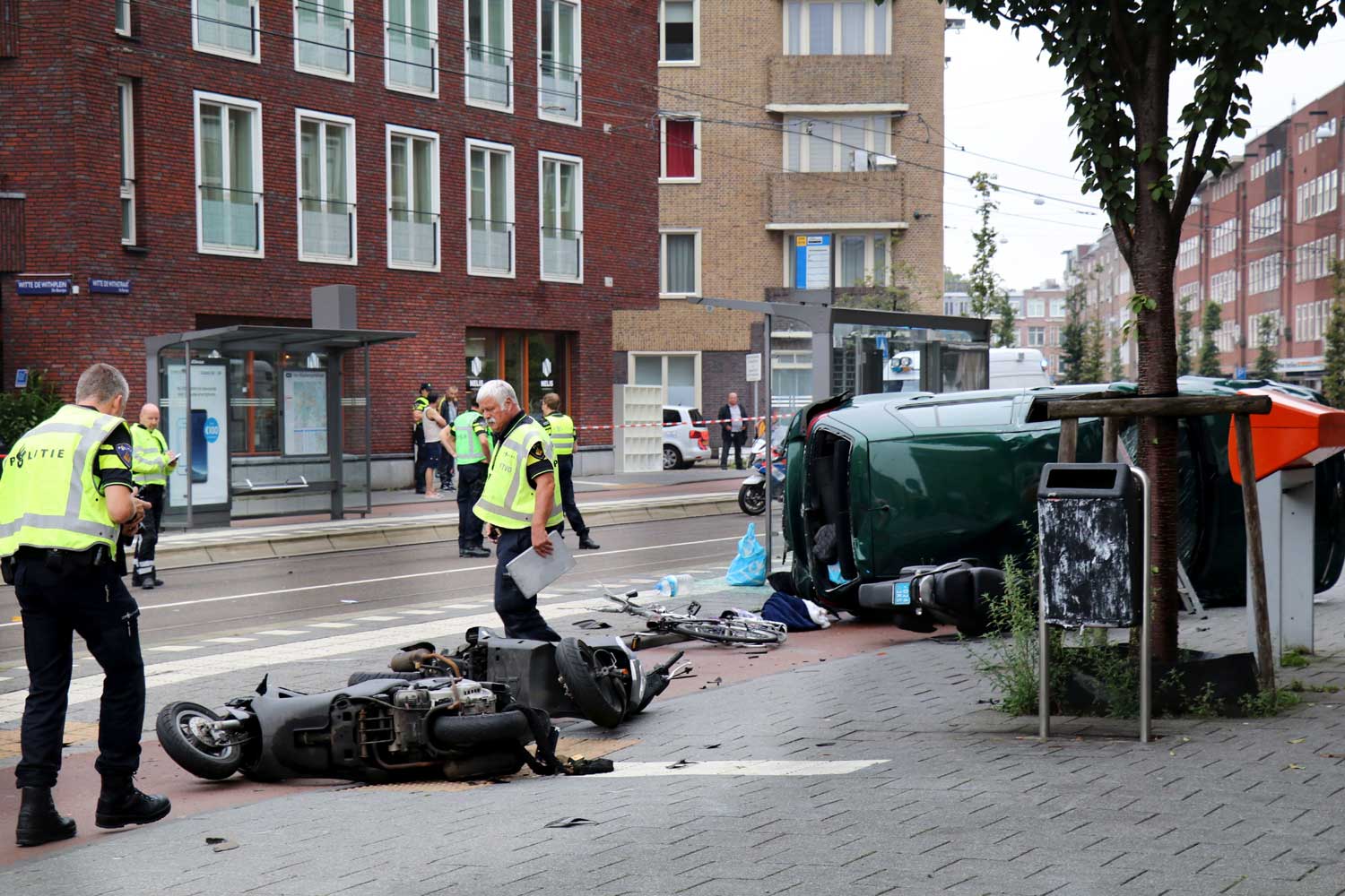 Auto over de kop raakt vrouw in Amsterdam