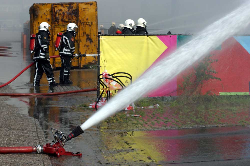 Foto van brandweerman blussen slang | Archief EHF