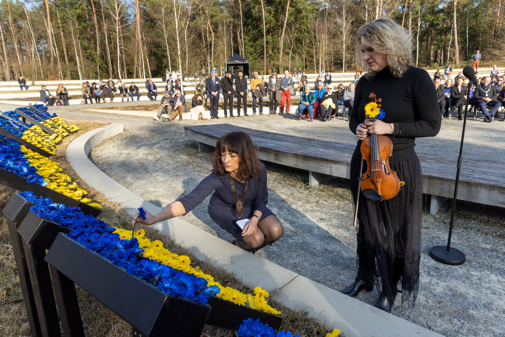 De Oekraïense Iryna Savenko en de Russische Anastasia Kozlova steken de laatste bloemen in het vredesmonument.