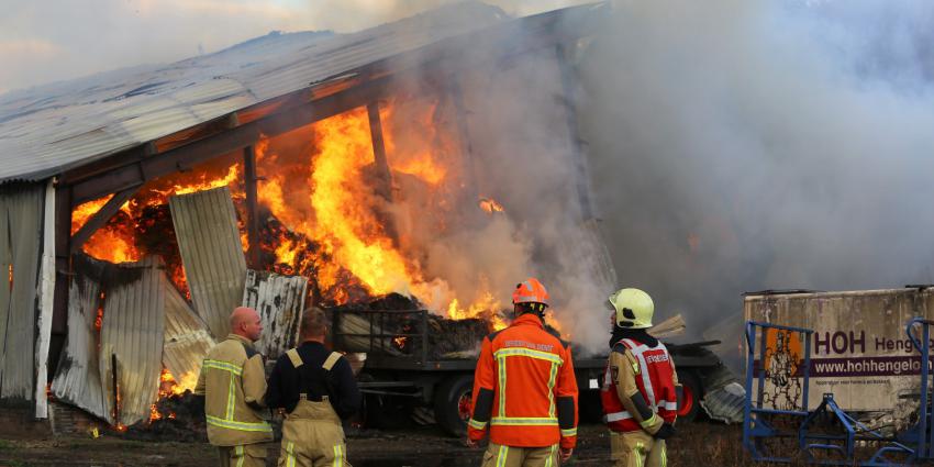 Brandweer bij in brand staande loods