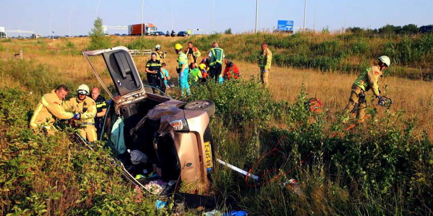 Vrouw met auto van talud snelweg A58 bij Eindhoven