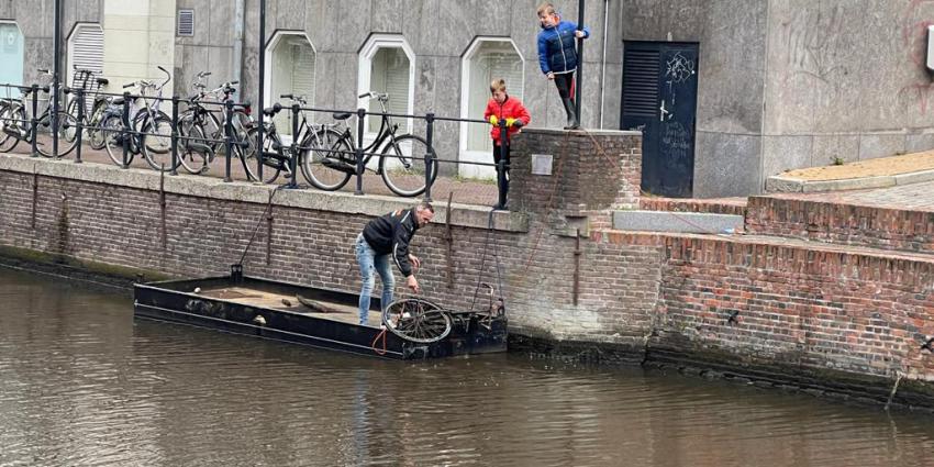 een oude fiets wordt uit het water gehaald