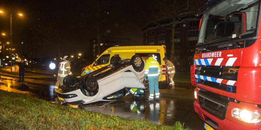 Bekneld in over de kop geslagen auto