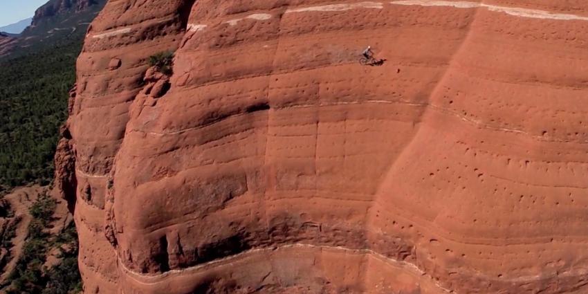 Mountainbiker fietst op levensgevaarlijke richel van steile berg