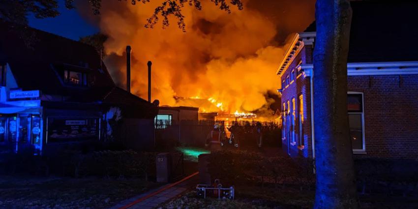Vlammen slaan uit dak van schuur