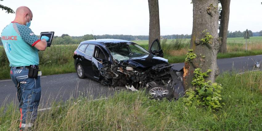 Ambulancemedewerker neemt foto van gecrashte auto 