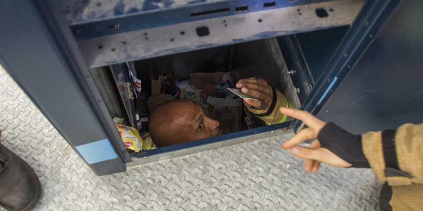 Brandweerman klimt in ondergrondse container voor verloren pinpas