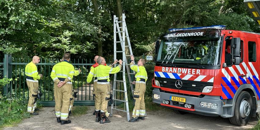 Brandweer klimt over hek