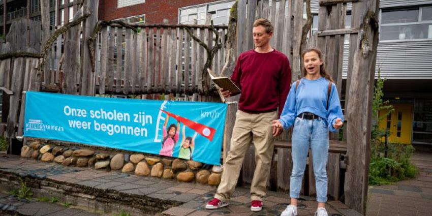 Justin Samgar en scholier Anna dragen het gedicht “Onze scholen zijn weer begonnen” voor bij basisschool de Hasselbraam in Amsterdam.