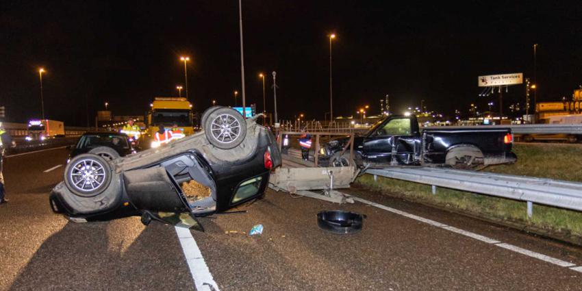 Auto op de kop, andere bovenop vangrail na aanrijding