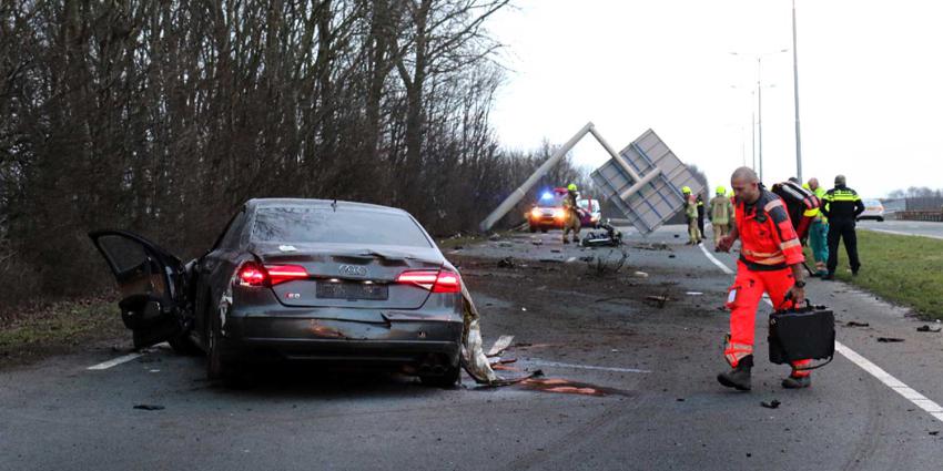 Auto klapt frontaal op paal verkeersbord
