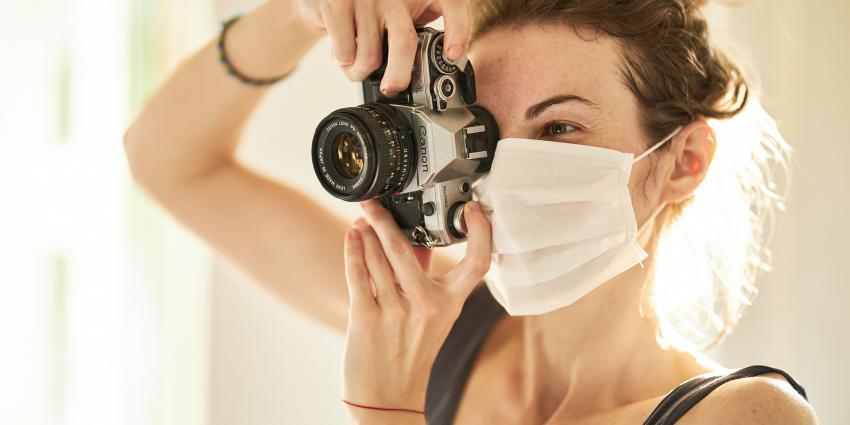 Vrouw met mondkapje en fototoestel