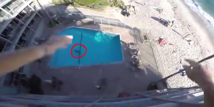 Man springt met actiecamera op hoofd van hoteldak in zwembad