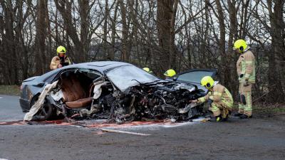Auto klapt frontaal op paal verkeersbord