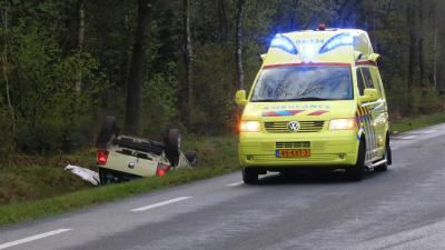 Vrouw met auto over de kop in sloot en bekneld