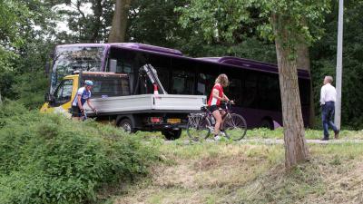 Vrouw op scootmobiel te water, kerende bus komt vast te zitten