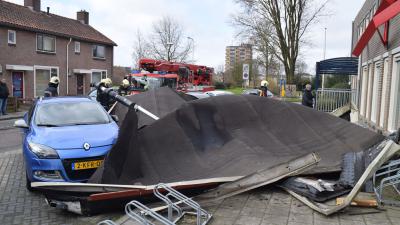 Dak waait van buurthuis waait op auto's