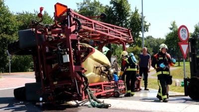 Landbouwtrekker met spuitmachine gekanteld