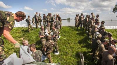 Foto van militairen die dijk verstevigen | Min. Defensie