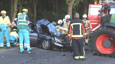 Vrouw in auto bekneld na aanrijding met tractor
