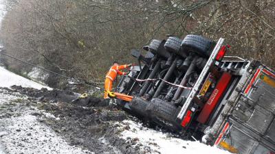 Truck met oplegger glijdt van de weg sloot in