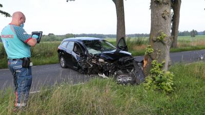 Ambulancemedewerker neemt foto van gecrashte auto 