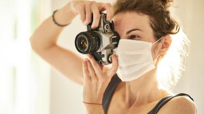 Vrouw met mondkapje en fototoestel