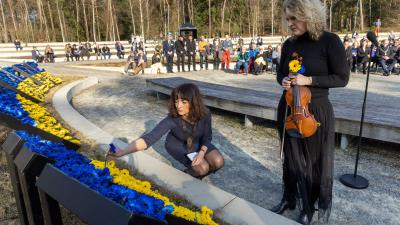 De Oekraïense Iryna Savenko en de Russische Anastasia Kozlova steken de laatste bloemen in het vredesmonument.